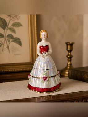 Vintage porcelain lady figurine dressed in an opalescent red and white dress
